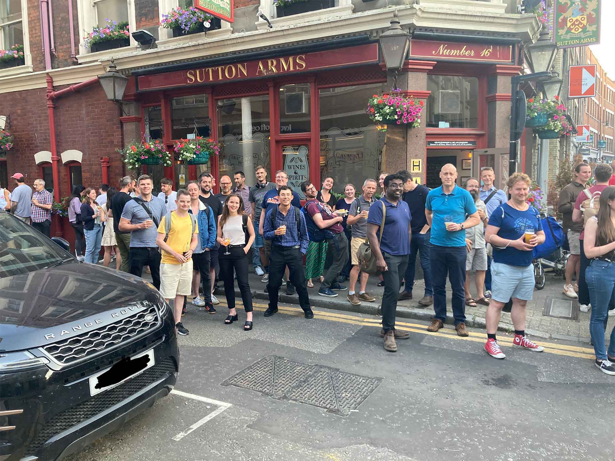 Large group of people gathered outside a pub